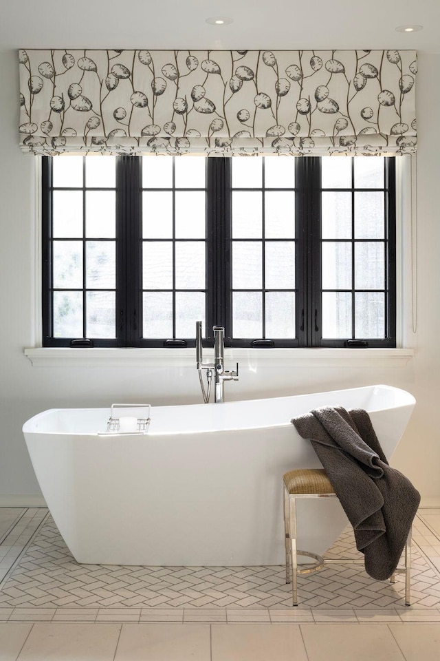 bathroom with a bathtub and tile flooring