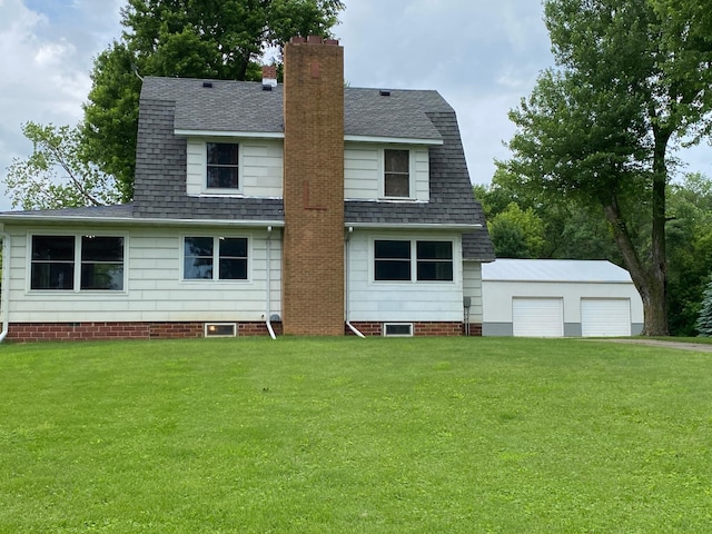 back of property with an outbuilding, a yard, and a garage