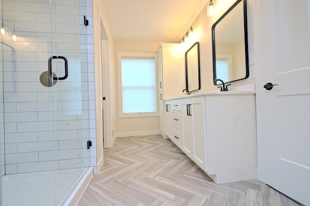 bathroom featuring a tile shower, vanity, and baseboards