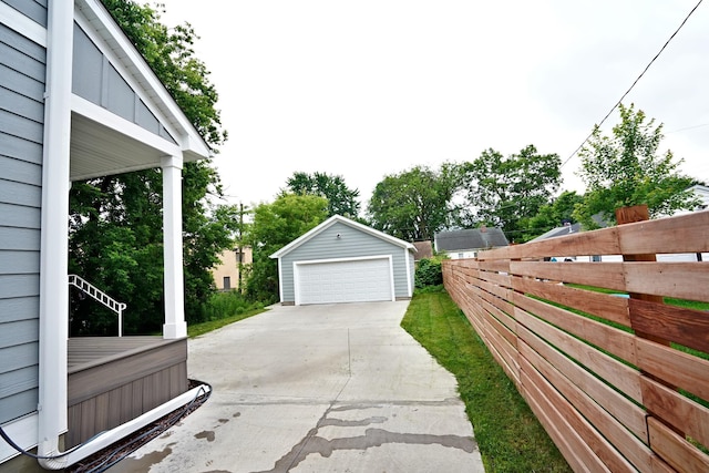 exterior space featuring an outbuilding, fence, and a garage