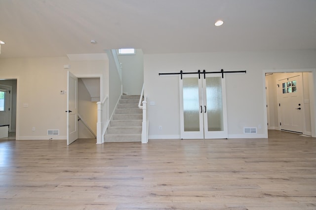 empty room with stairway, recessed lighting, visible vents, and light wood-style floors