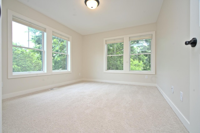 carpeted empty room with visible vents and baseboards