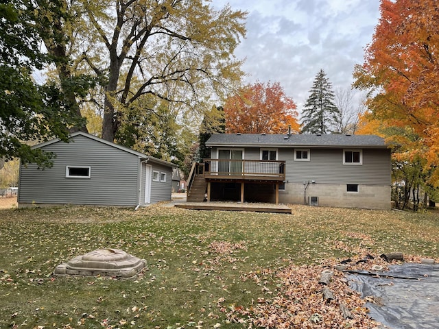 back of property with a wooden deck and a yard