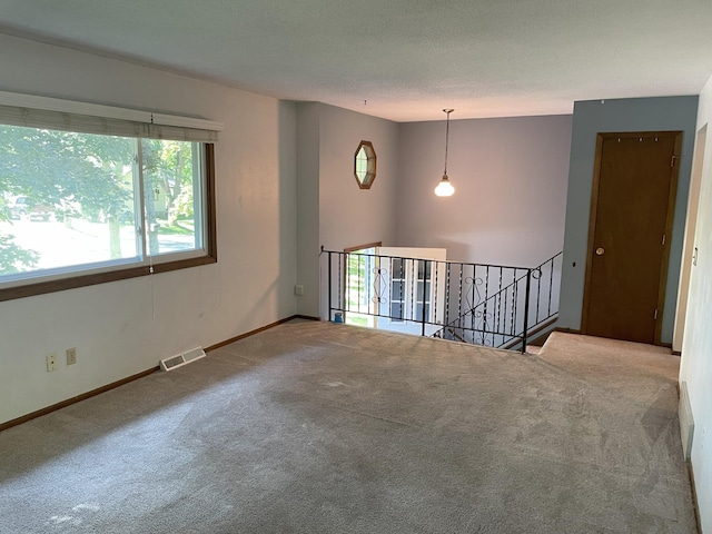 unfurnished room with a textured ceiling and carpet flooring