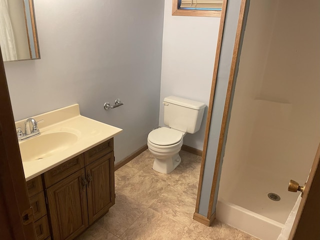 bathroom with vanity, toilet, and a shower