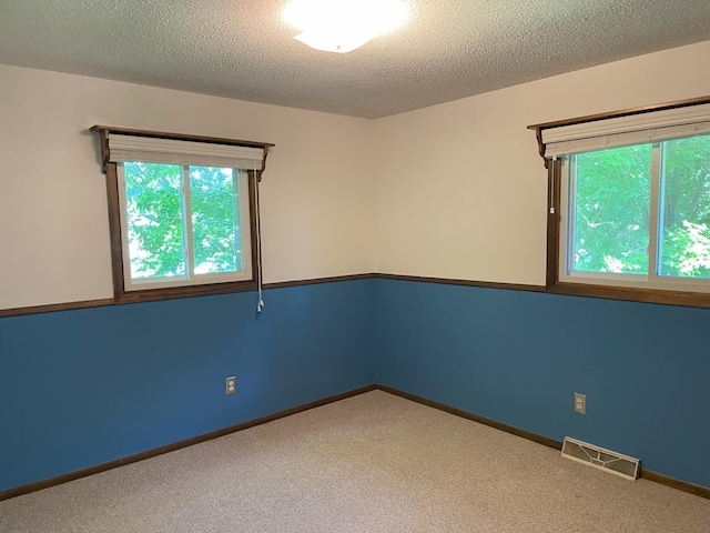 carpeted empty room with a textured ceiling