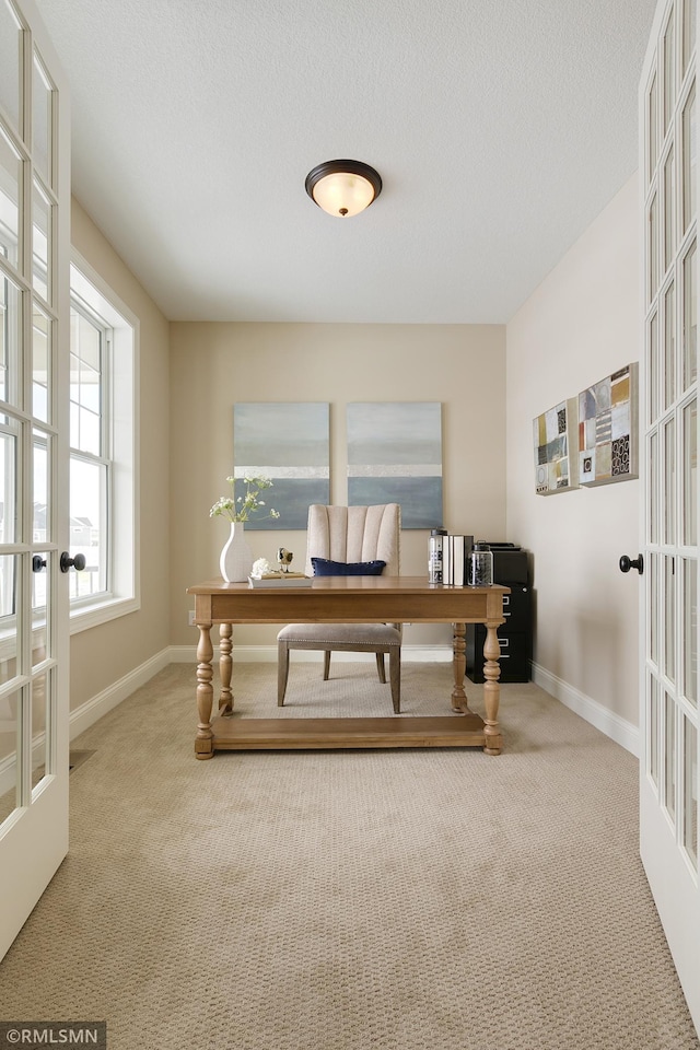 office space featuring a textured ceiling, carpet floors, and french doors