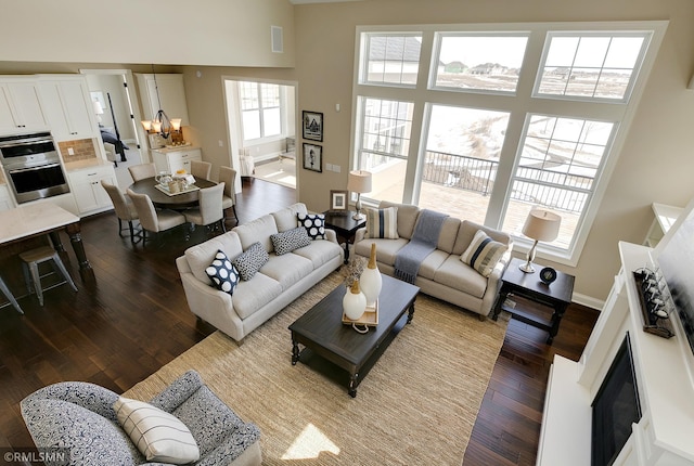 living room featuring a high ceiling, dark hardwood / wood-style floors, and a chandelier