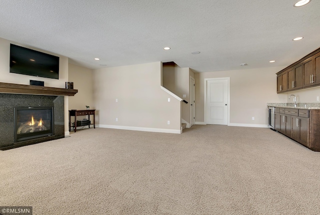 unfurnished living room with light carpet and a textured ceiling