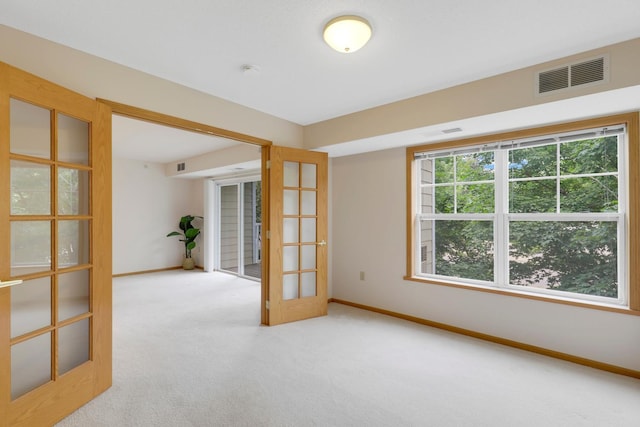 carpeted empty room with french doors and plenty of natural light