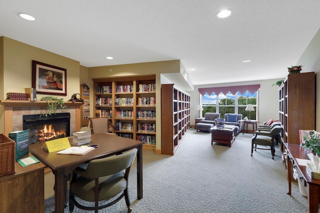 office area with a textured ceiling, carpet, and a fireplace