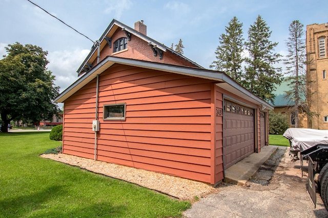 exterior space featuring a garage and a lawn