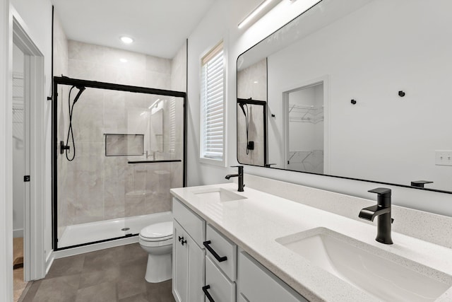 bathroom featuring vanity, toilet, and a shower with door