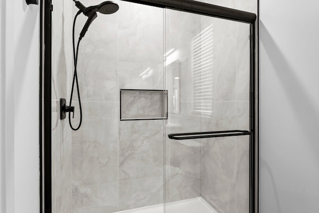 bathroom featuring a shower with door