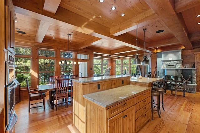 kitchen featuring light hardwood / wood-style floors, wooden ceiling, hanging light fixtures, and a center island