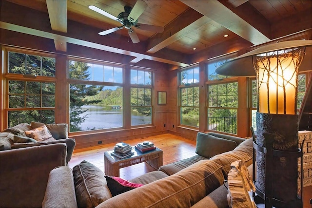 living room featuring a water view, beam ceiling, wood ceiling, and wooden walls