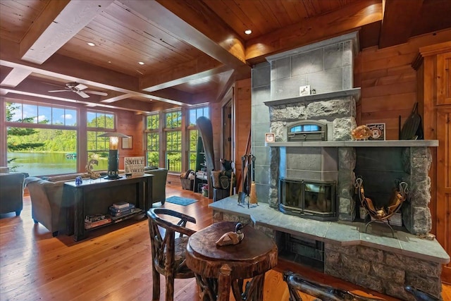 living room featuring ceiling fan, a healthy amount of sunlight, beamed ceiling, and light hardwood / wood-style flooring