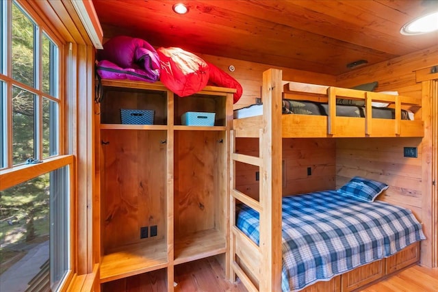 bedroom with wood-type flooring, wood ceiling, and wood walls