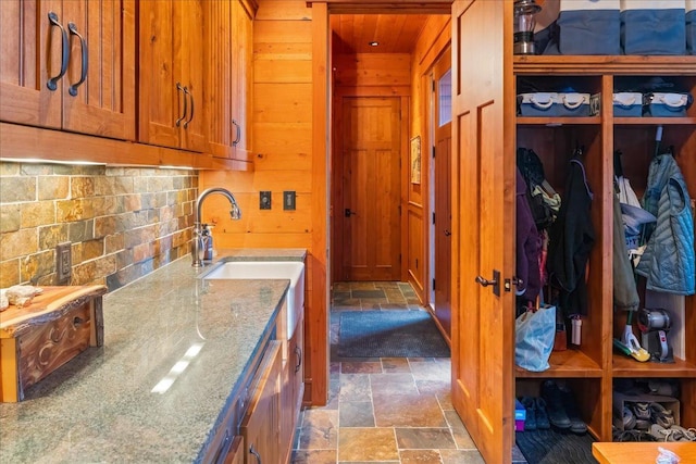 interior space featuring wood ceiling, light stone counters, and wooden walls