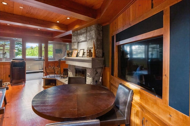 dining space with a fireplace, beamed ceiling, hardwood / wood-style flooring, baseboard heating, and wooden ceiling