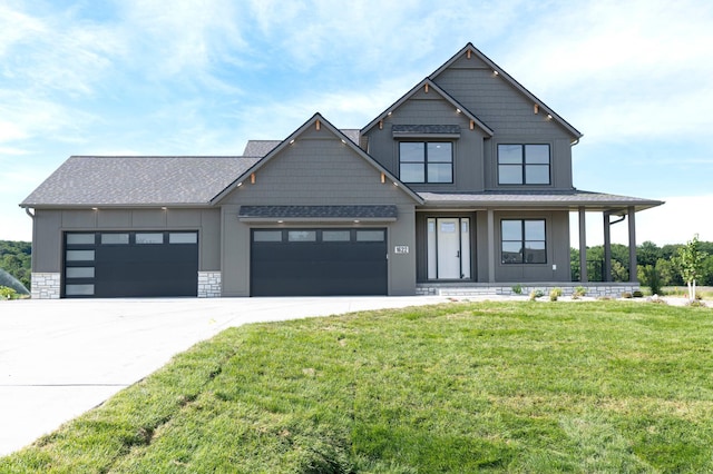 view of front of property featuring concrete driveway, board and batten siding, a front yard, a garage, and stone siding