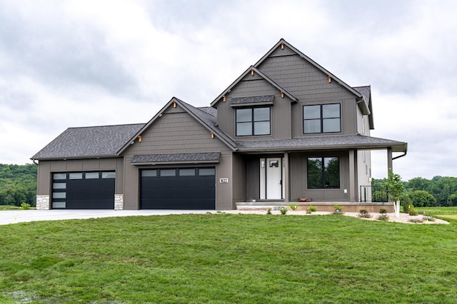 view of front of property featuring an attached garage, concrete driveway, stone siding, board and batten siding, and a front yard