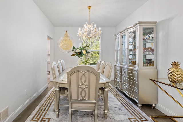 dining area with dark hardwood / wood-style flooring and a chandelier