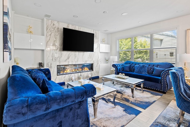 living room featuring a high end fireplace and wood-type flooring