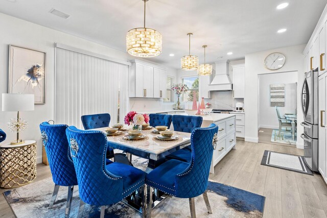 dining area featuring light hardwood / wood-style floors and a notable chandelier