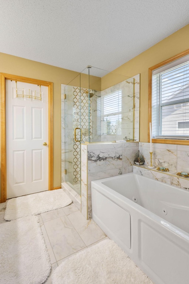 bathroom featuring separate shower and tub and a textured ceiling