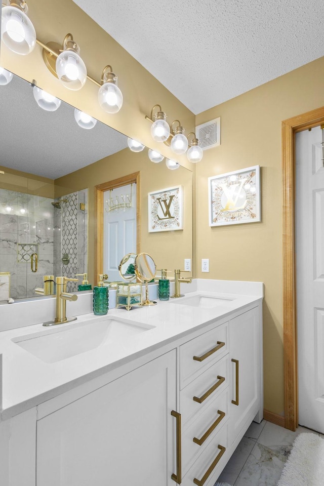 bathroom with vanity, a textured ceiling, and walk in shower