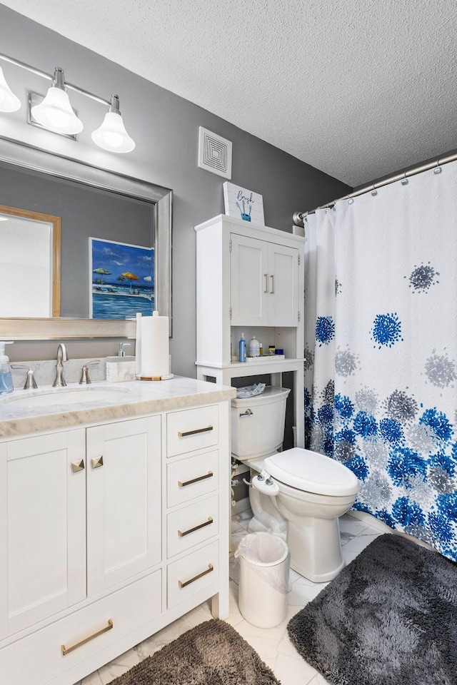 bathroom with tile patterned floors, vanity, a textured ceiling, and toilet