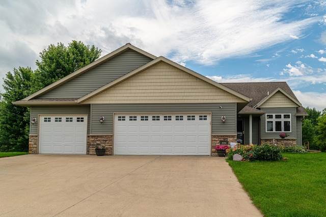 craftsman inspired home featuring a garage and a front lawn