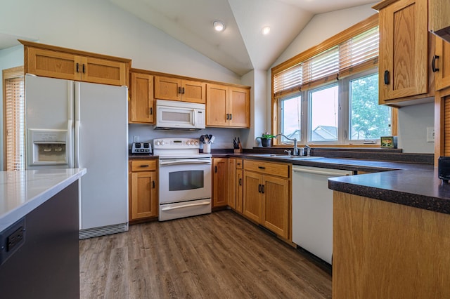 kitchen featuring vaulted ceiling, sink, dark hardwood / wood-style floors, and white appliances