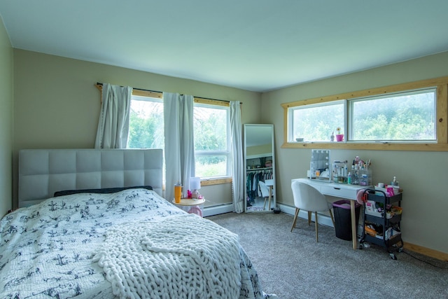 bedroom featuring multiple windows, baseboard heating, and carpet