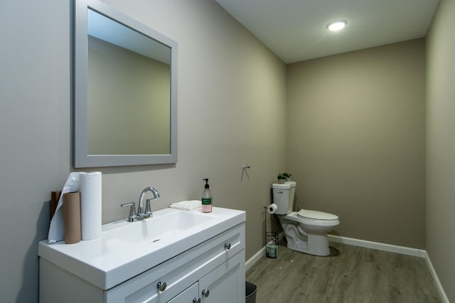 bathroom with vanity, wood-type flooring, and toilet