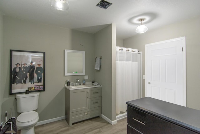 bathroom featuring vanity, wood-type flooring, and toilet