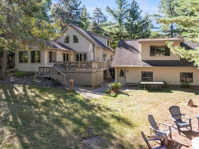 rear view of house featuring a deck and a lawn