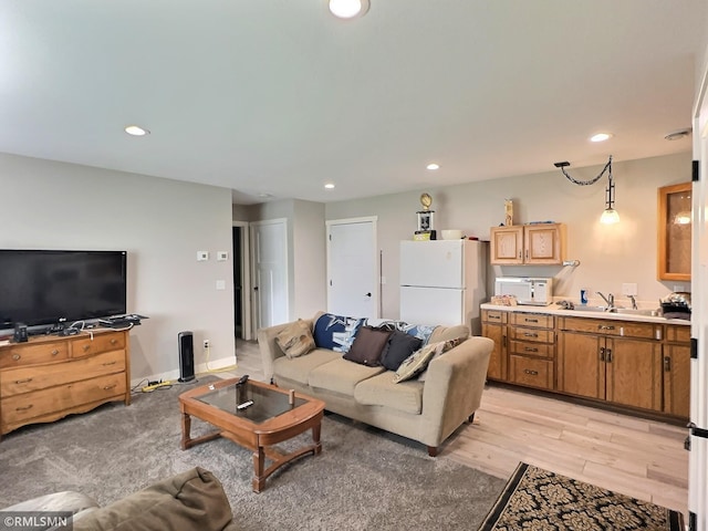 living area with light wood-style flooring and recessed lighting