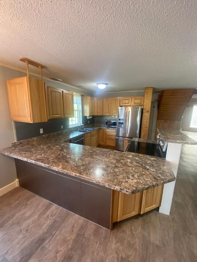 kitchen featuring sink, appliances with stainless steel finishes, kitchen peninsula, and dark hardwood / wood-style flooring