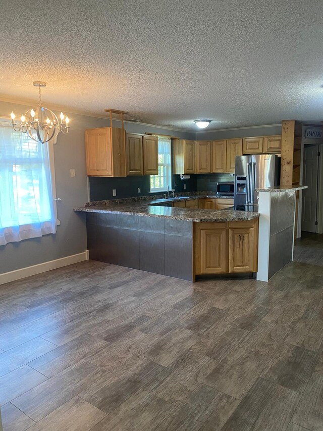 kitchen with an inviting chandelier, appliances with stainless steel finishes, hanging light fixtures, and a wealth of natural light