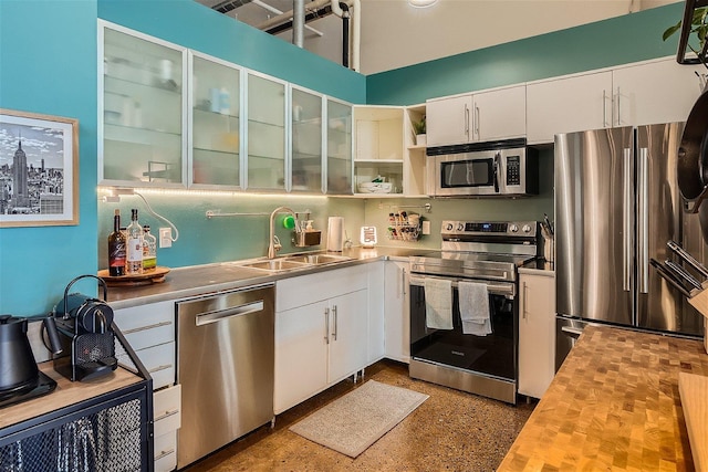 kitchen featuring white cabinetry, sink, wooden counters, and appliances with stainless steel finishes