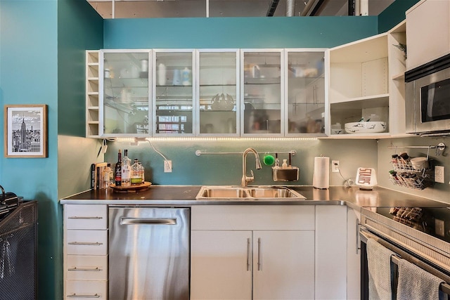 bar featuring appliances with stainless steel finishes, white cabinetry, stainless steel counters, and sink