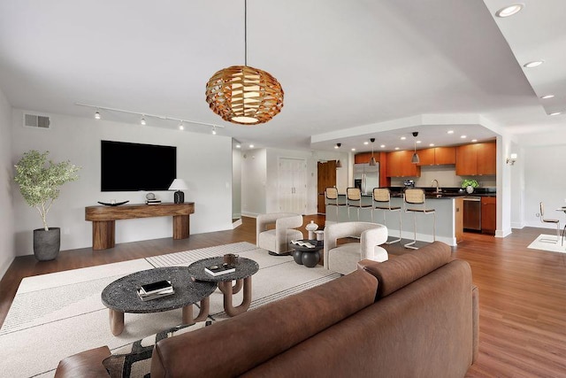 living room featuring sink and dark hardwood / wood-style flooring