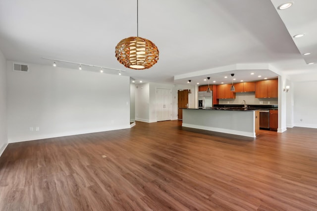 unfurnished living room featuring sink and dark hardwood / wood-style floors