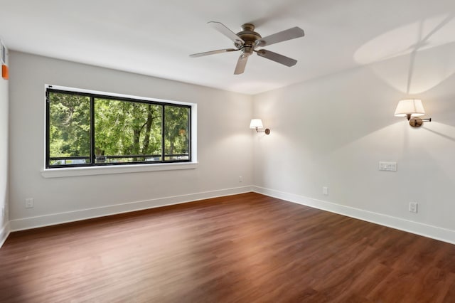 empty room with dark hardwood / wood-style floors and ceiling fan