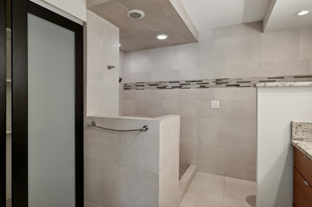 bathroom with vanity, tile walls, tile patterned floors, and walk in shower