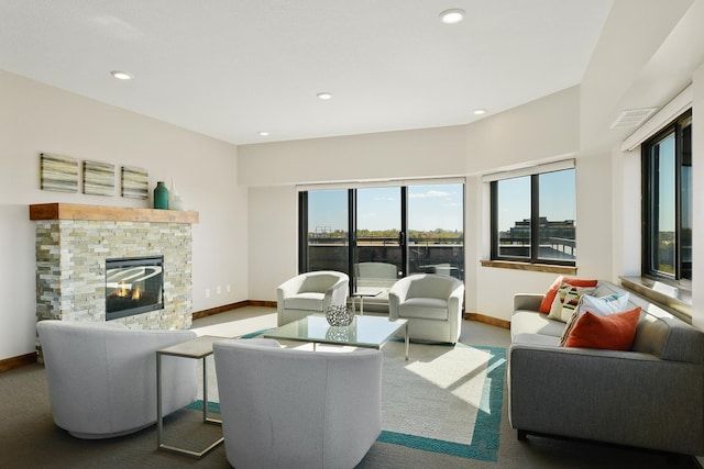 carpeted living room with a stone fireplace