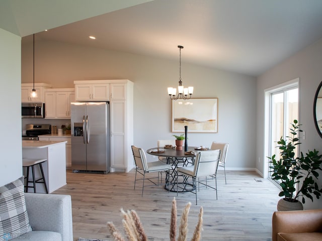 dining space featuring a chandelier, light hardwood / wood-style floors, and vaulted ceiling