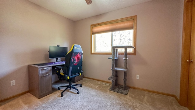 carpeted office space featuring ceiling fan